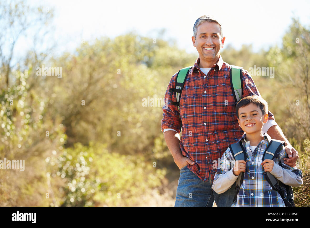 Father And Son Hiking In Countryside Wearing Backpacks Stock Photo