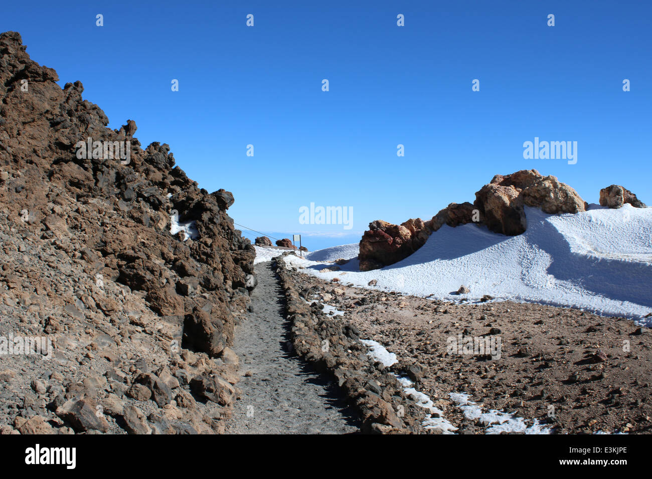 Hiking through snow at 3500m on the mountain peak of El Teide Volcano, highest summit on the Spanish Canary island of Tenerife Stock Photo