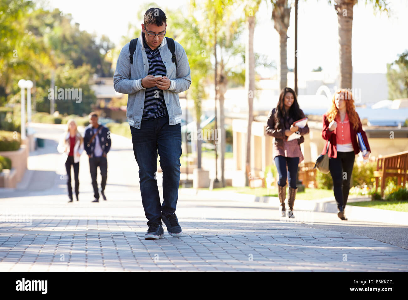 Students Walking Outdoors On University Campus Stock Photo