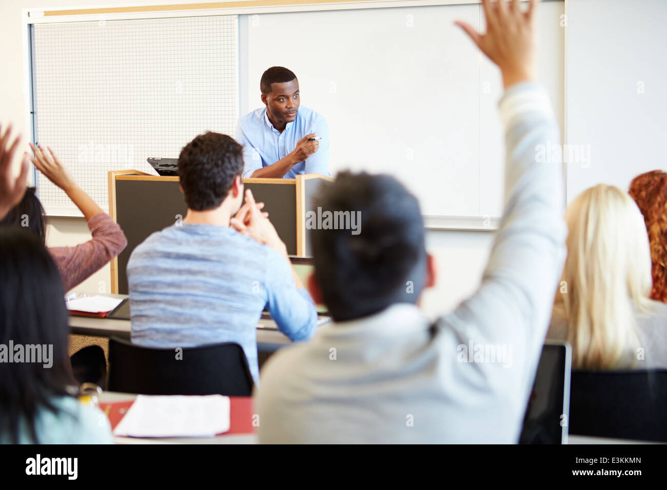 Male Tutor Teaching University Students In Classroom Stock Photo