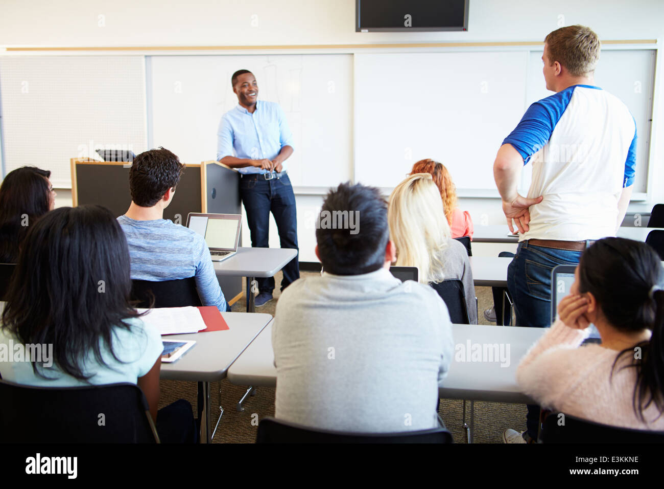 Male Tutor Teaching University Students In Classroom Stock Photo