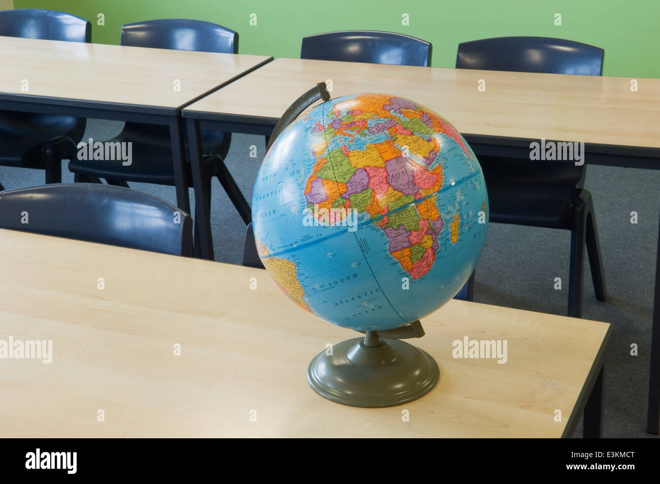 World globe on a desk in a modern school classroom. Stock Photo