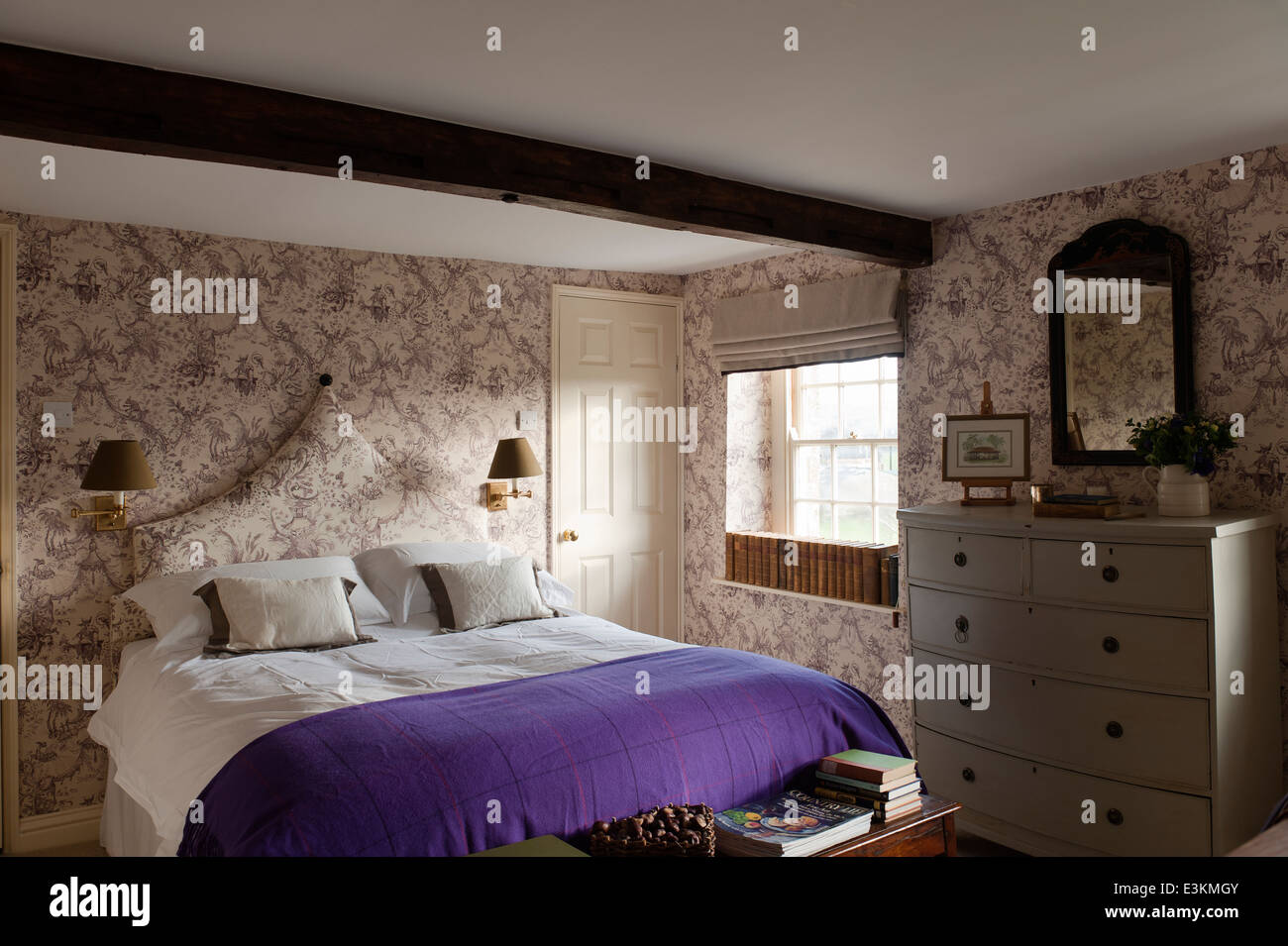 Beamed attic bedroom with Asticou wallpaper and matching headboard by Nina Campbell Stock Photo