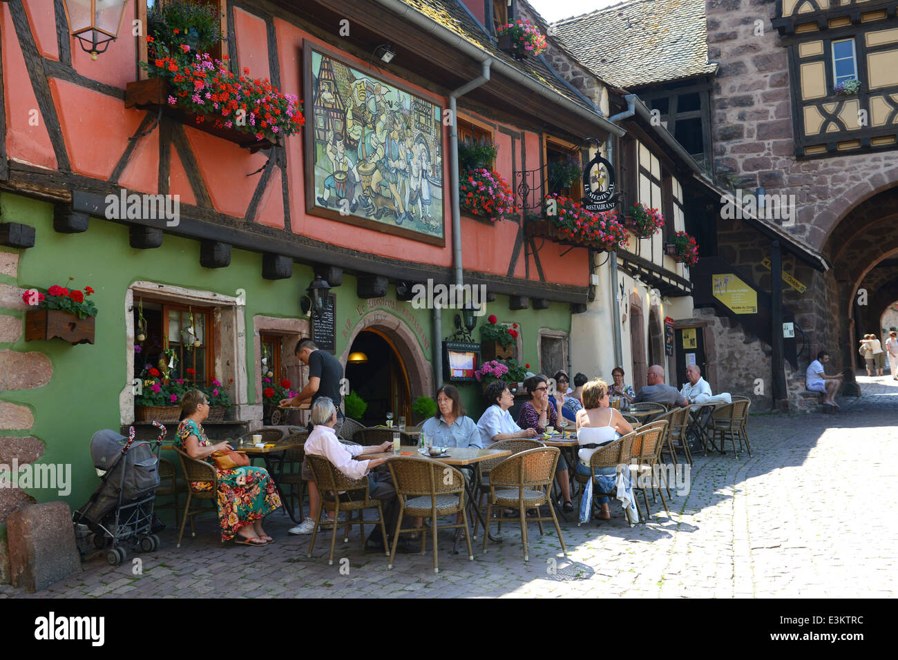 People eating outside The Medieval Restaurant in Riquewihr Alsace region France Stock Photo