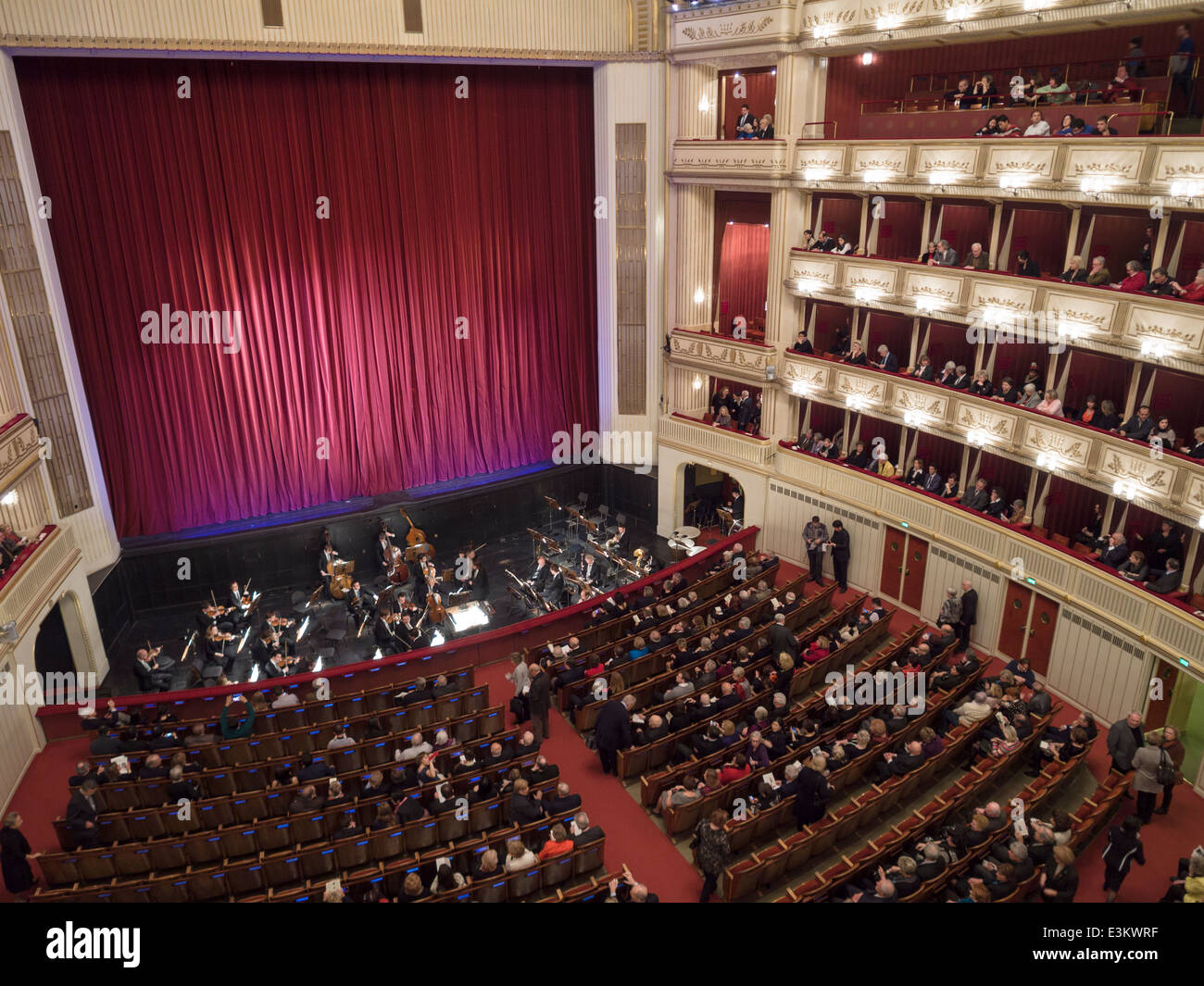 Curtained stage patrons and the Orchestra get seated. The stage is
