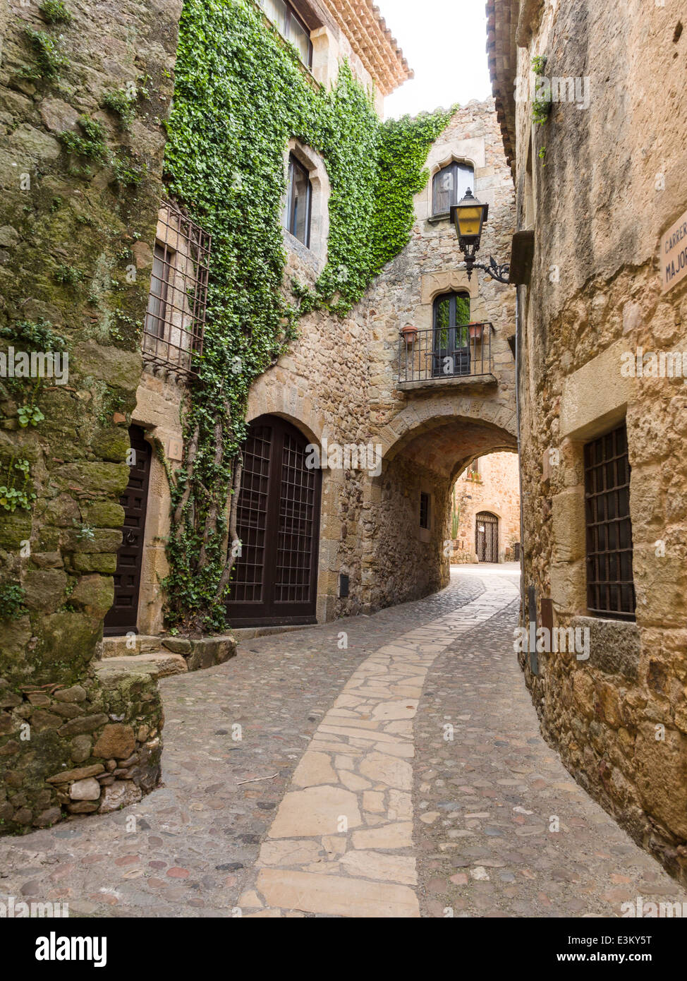 Winding Back street in Pals. A curved path/street in Pals leads to a private courtyard. Ivy grows decoratively up the walls Stock Photo