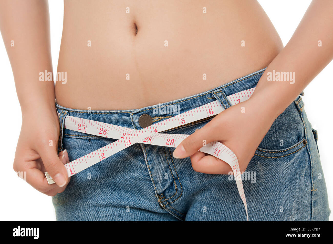 A very fit Caucasian woman measuring her waist isolated on a white background Stock Photo