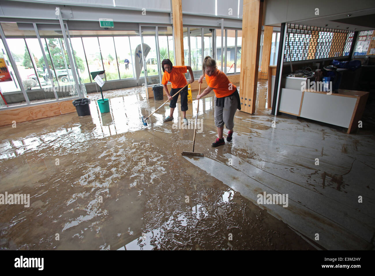 Staff cleaning muddy silt from Saxton Stadium after flooding, April 2013, Richmond, Nelson, New Zealand Stock Photo