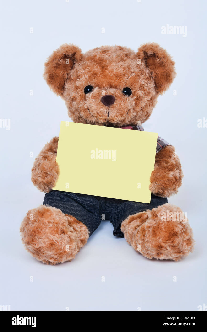 A cute teddy bear holding a blank yellow sign on a white background ...