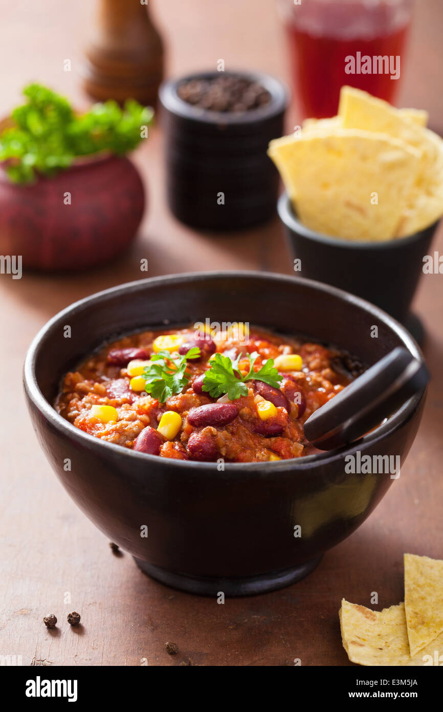 mexican chili con carne in black plate with ingredients Stock Photo