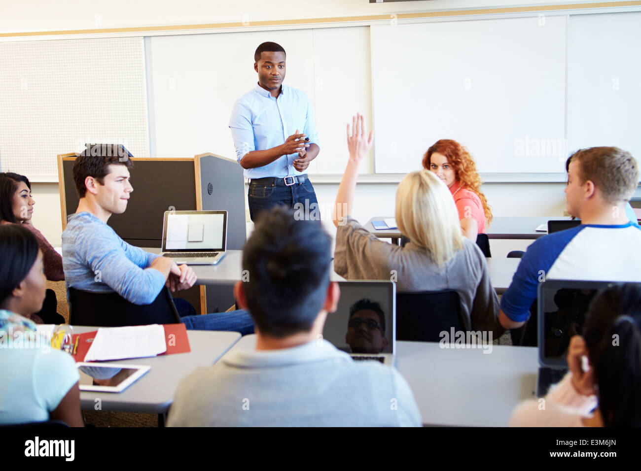 Male Tutor Teaching University Students In Classroom Stock Photo