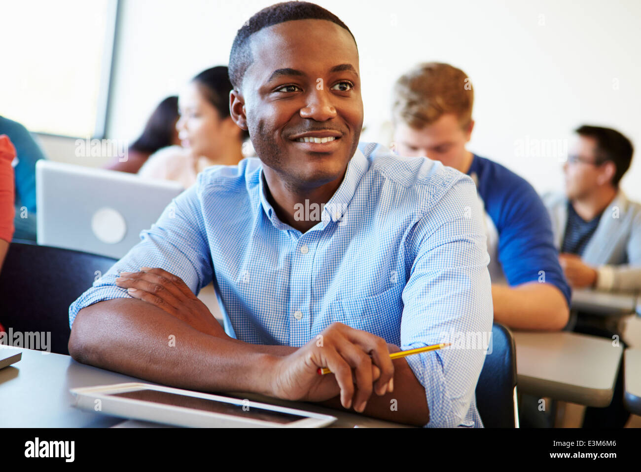Male University Student Using Digital Tablet In Classroom Stock Photo