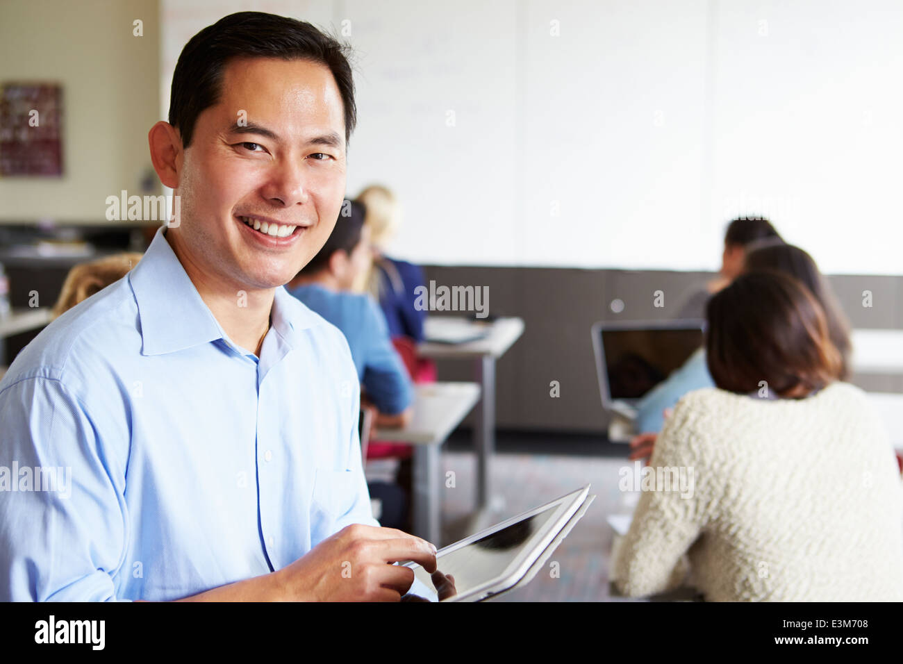 High School Teacher With Digital Tablet In Classroom Stock Photo - Alamy