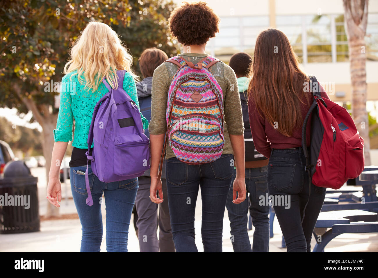 Rear View Of Students Walking To High School Stock Photo