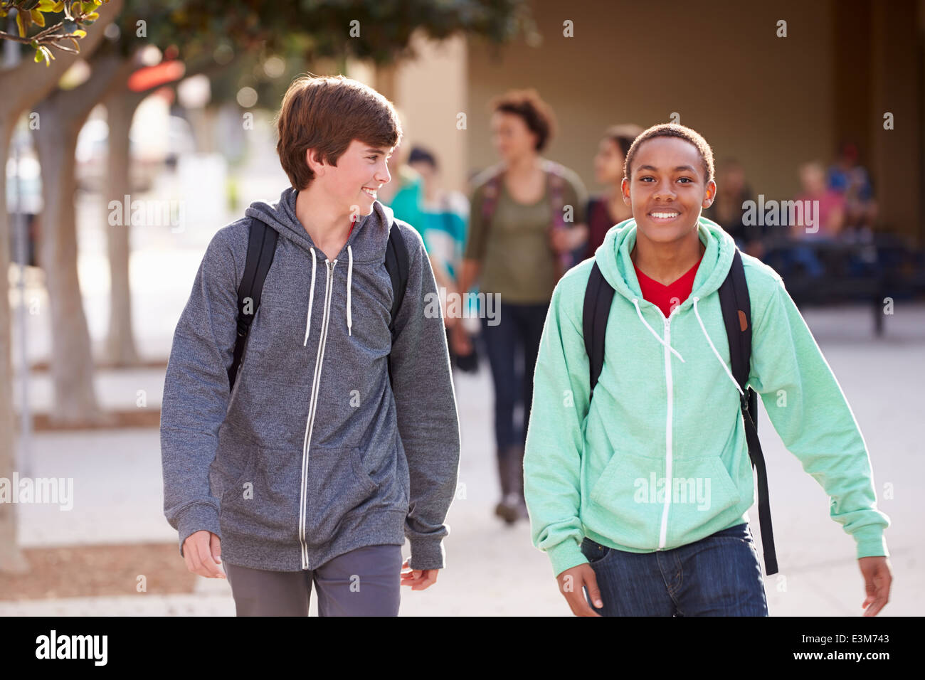 Two Male Students Walking To High School Stock Photo