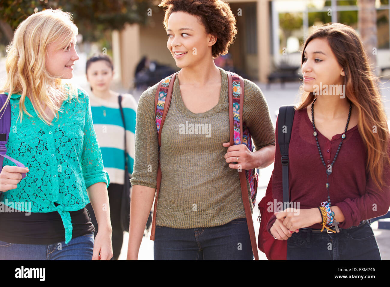Three Female Students Walking To High School Stock Photo