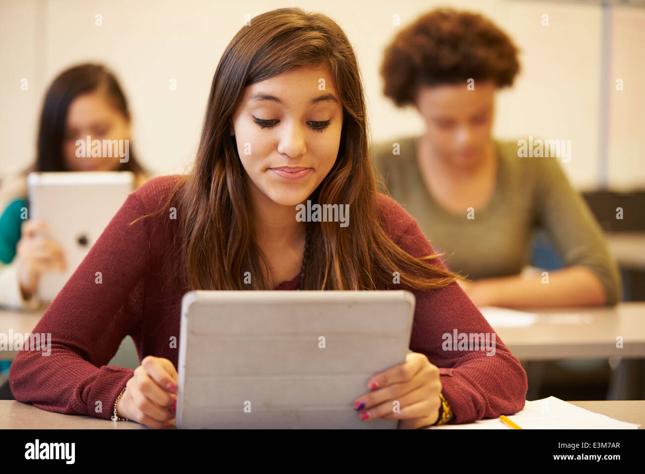 High School Student At Desk In Class Using Digital Tablet Stock Photo