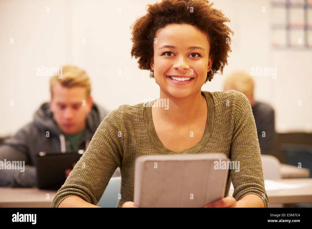 High School Student At Desk In Class Using Digital Tablet Stock Photo
