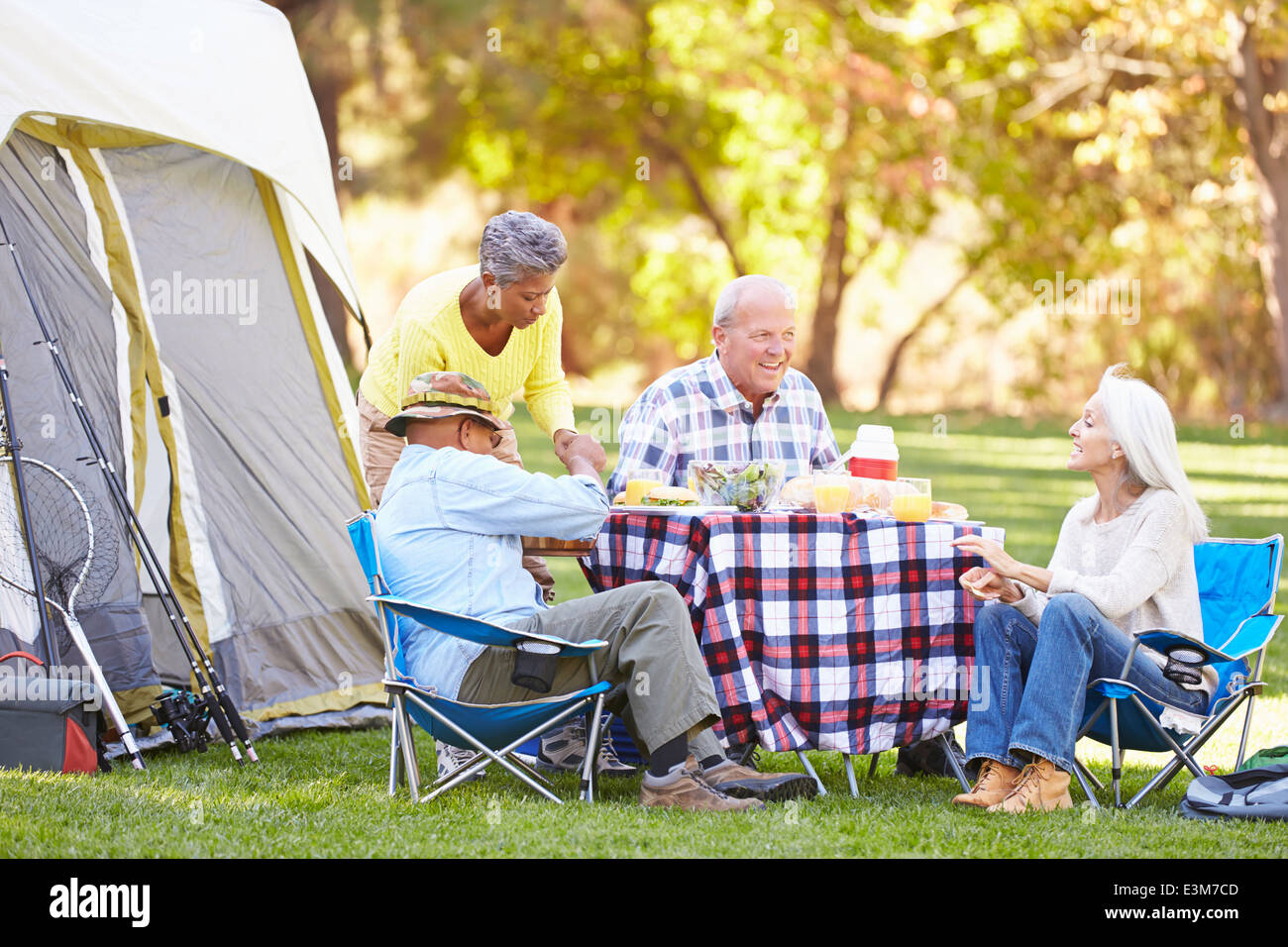 Two Senior Couples Enjoying Camping Holiday In Countryside Stock Photo