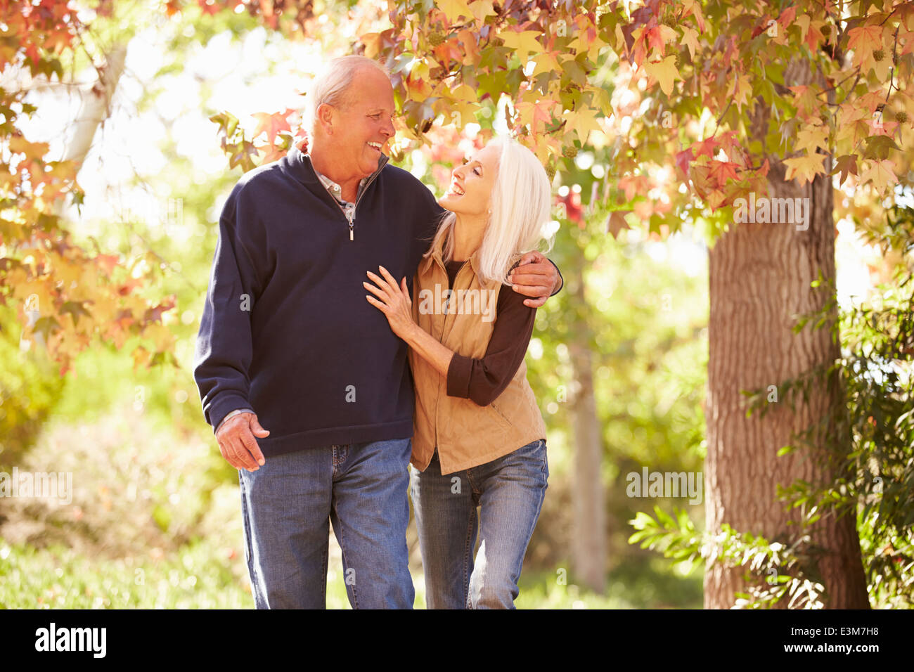 Senior Couple Walking Through Autumn Woodland Stock Photo - Alamy