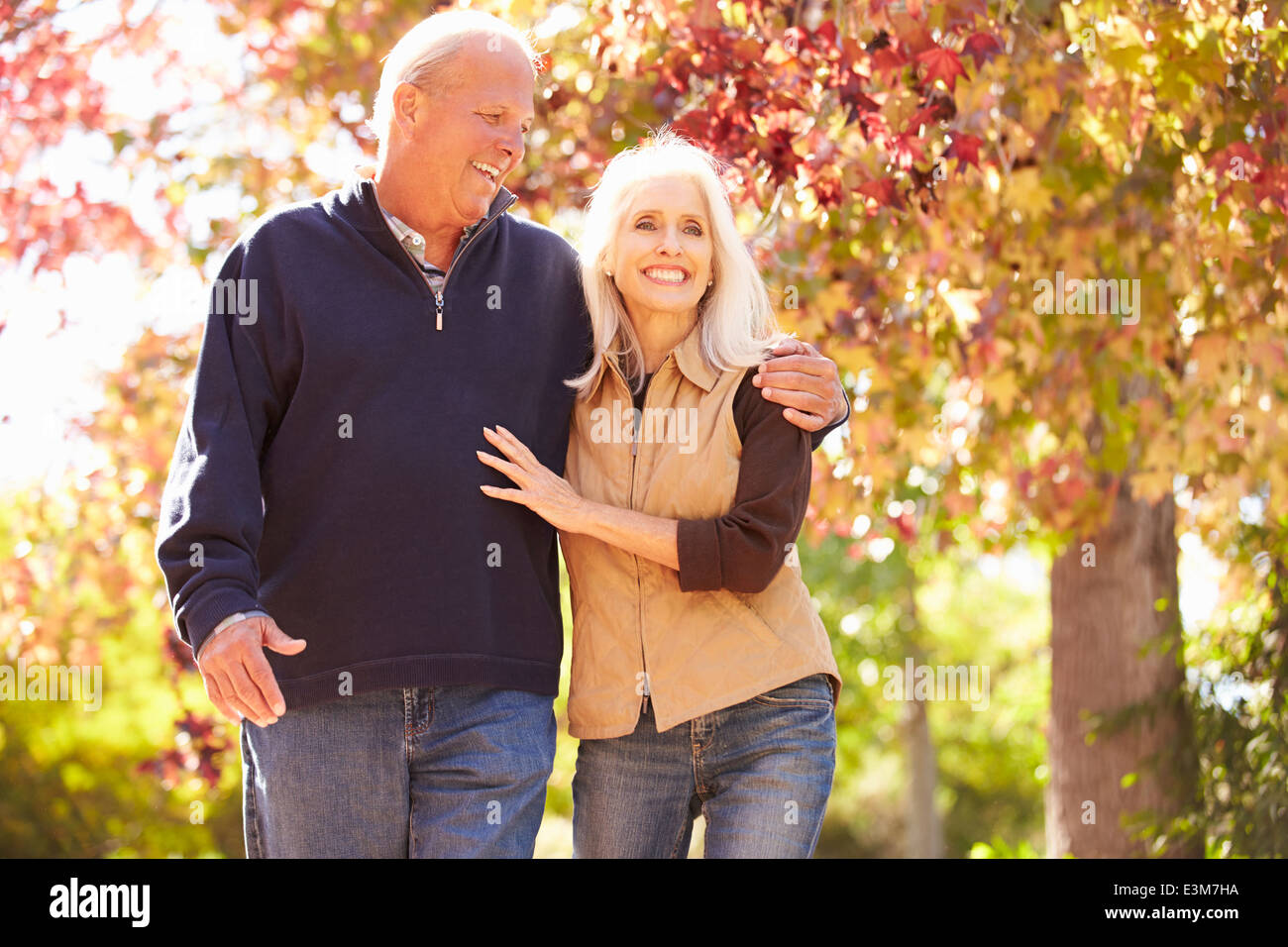 Senior Couple Walking Through Autumn Woodland Stock Photo - Alamy