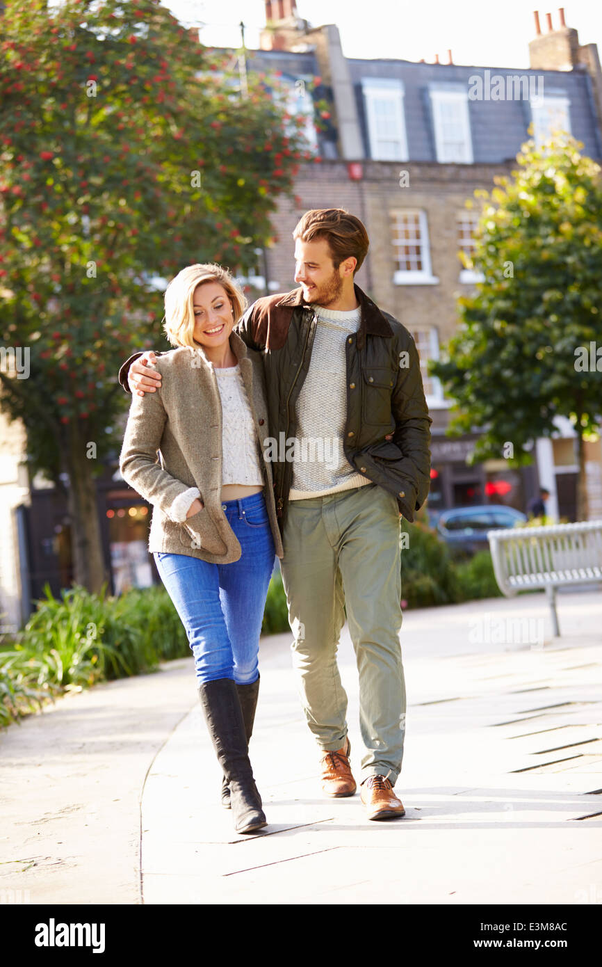 Young Couple Walking Through City Park Together Stock Photo