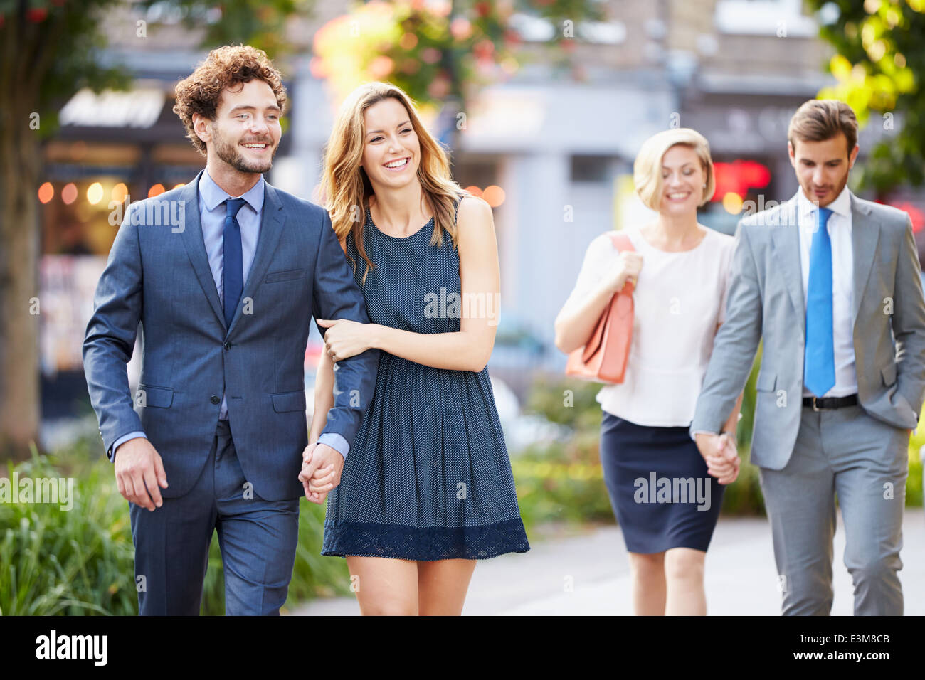 Young Business Couples Walking Through City Park Together Stock Photo