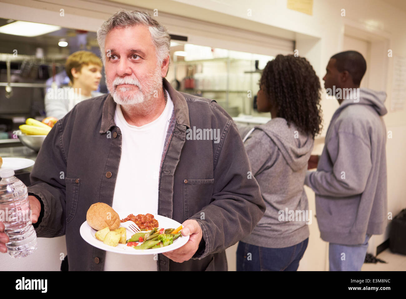 Kitchen Serving Food In Homeless Shelter Stock Photo