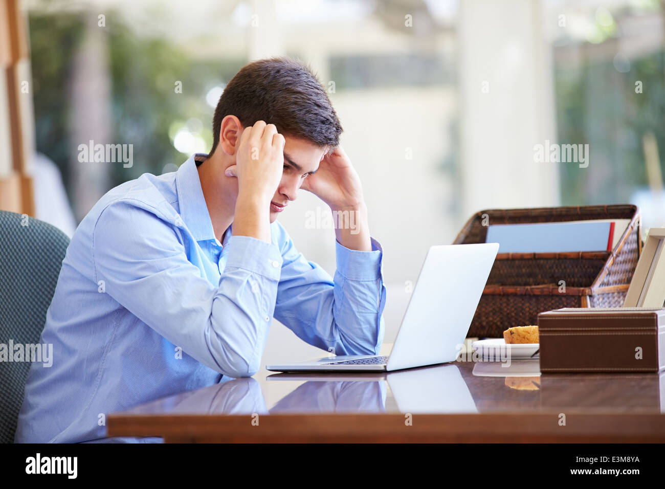 Stressed Teenage Boy Using Laptop On Desk At Home Stock Photo - Alamy