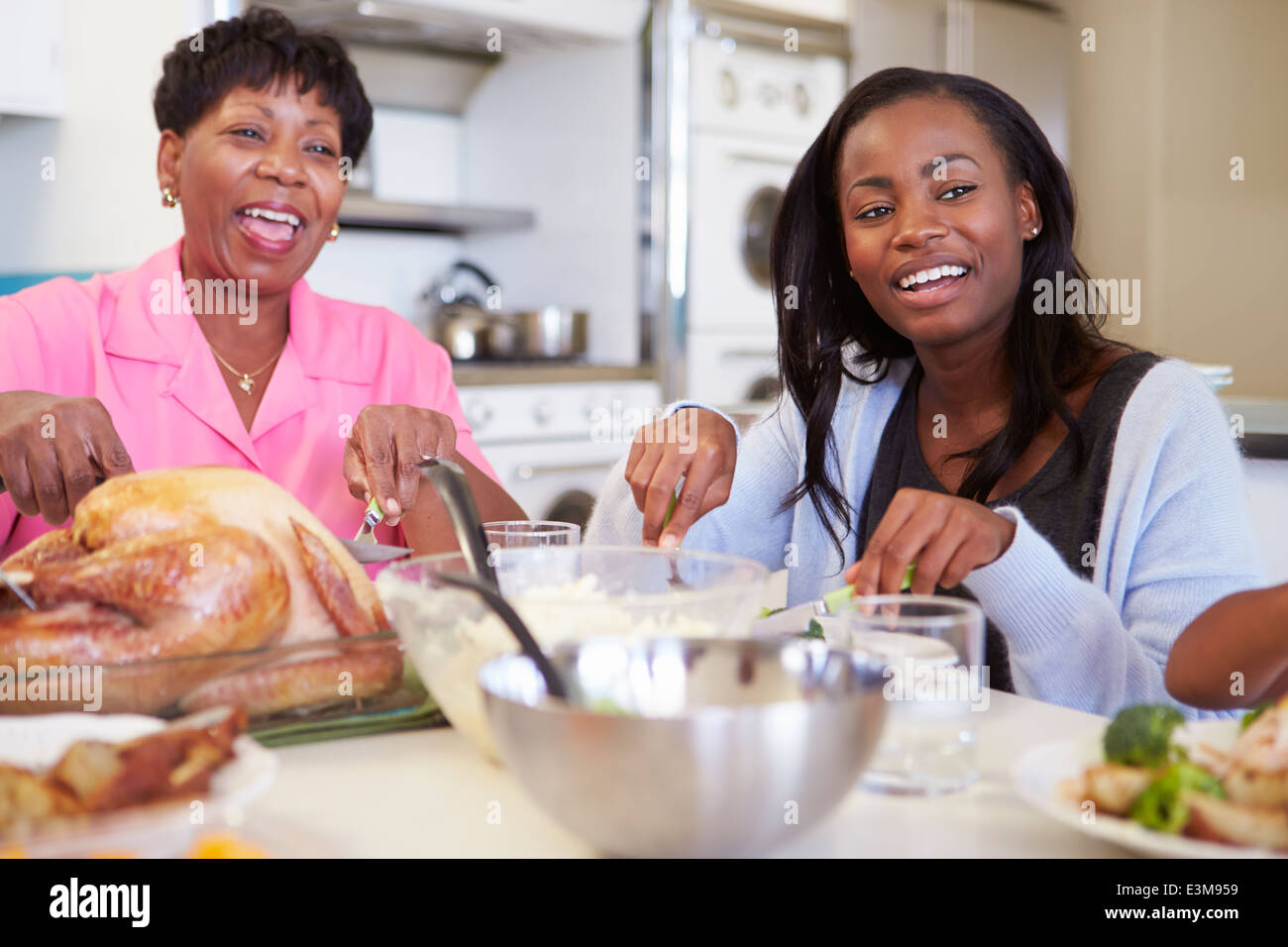 Mother And Adult Daughter Having Family Meal At Table Stock Photo