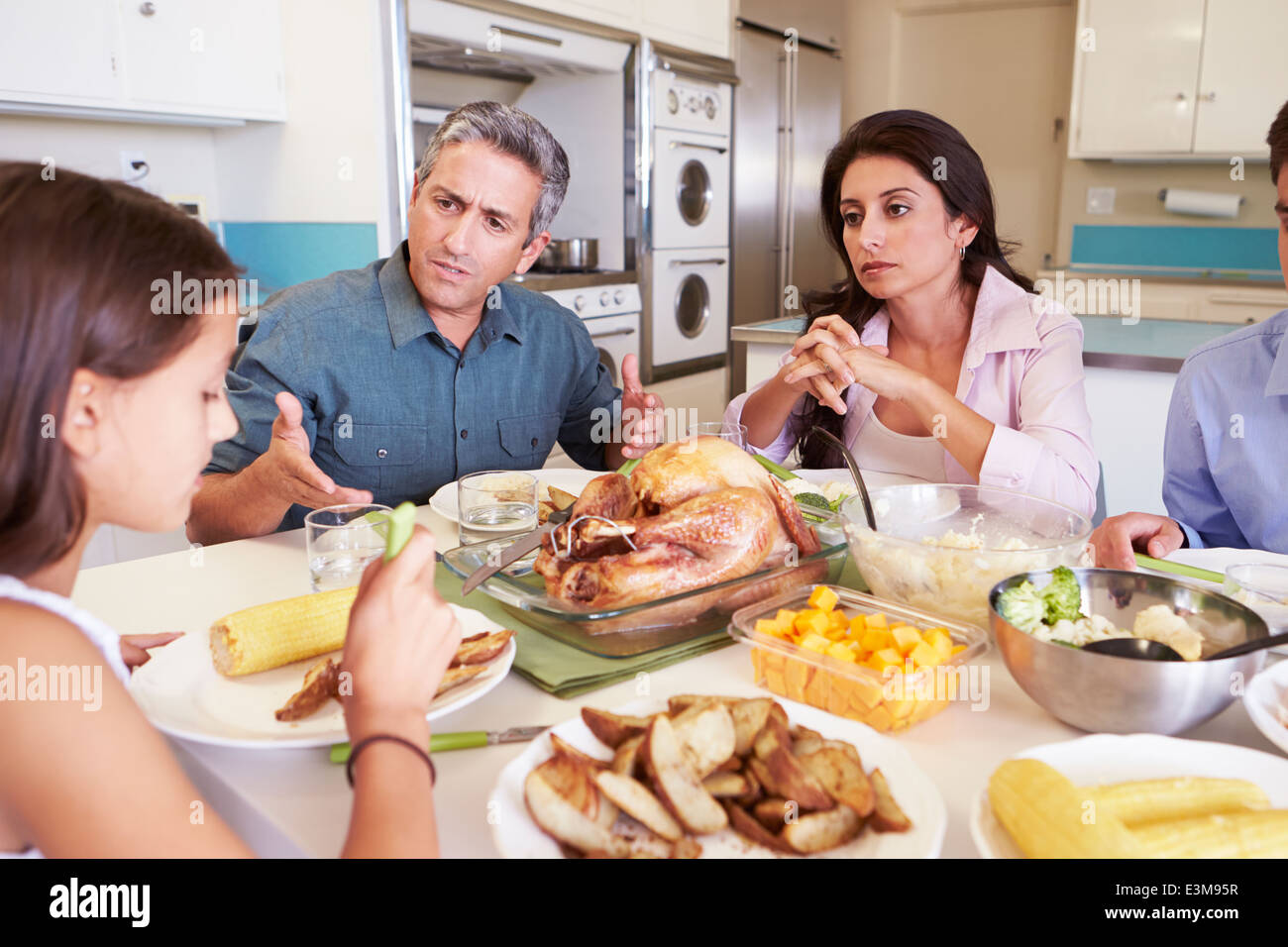Family Having Argument Sitting Around Table Eating Meal Stock Photo