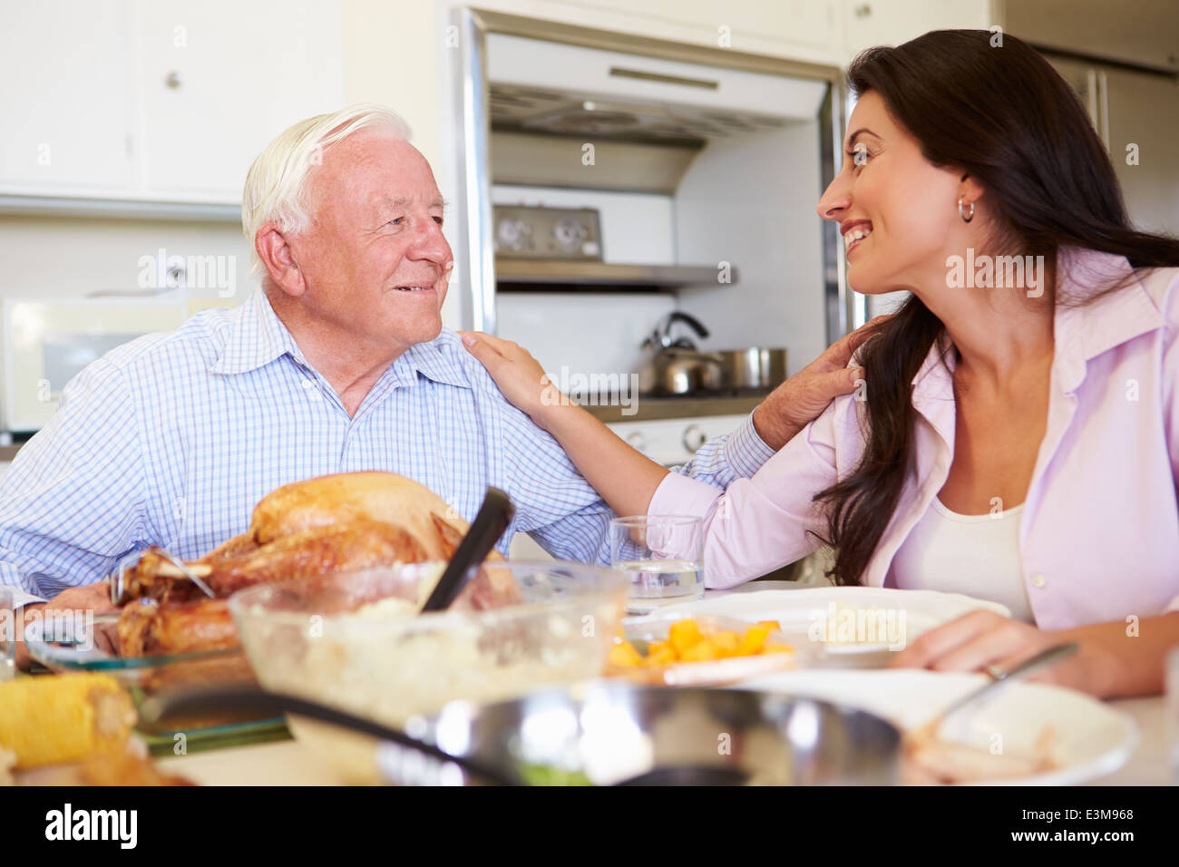 Father And Adult Daughter Having Family Meal At Table Stock Photo