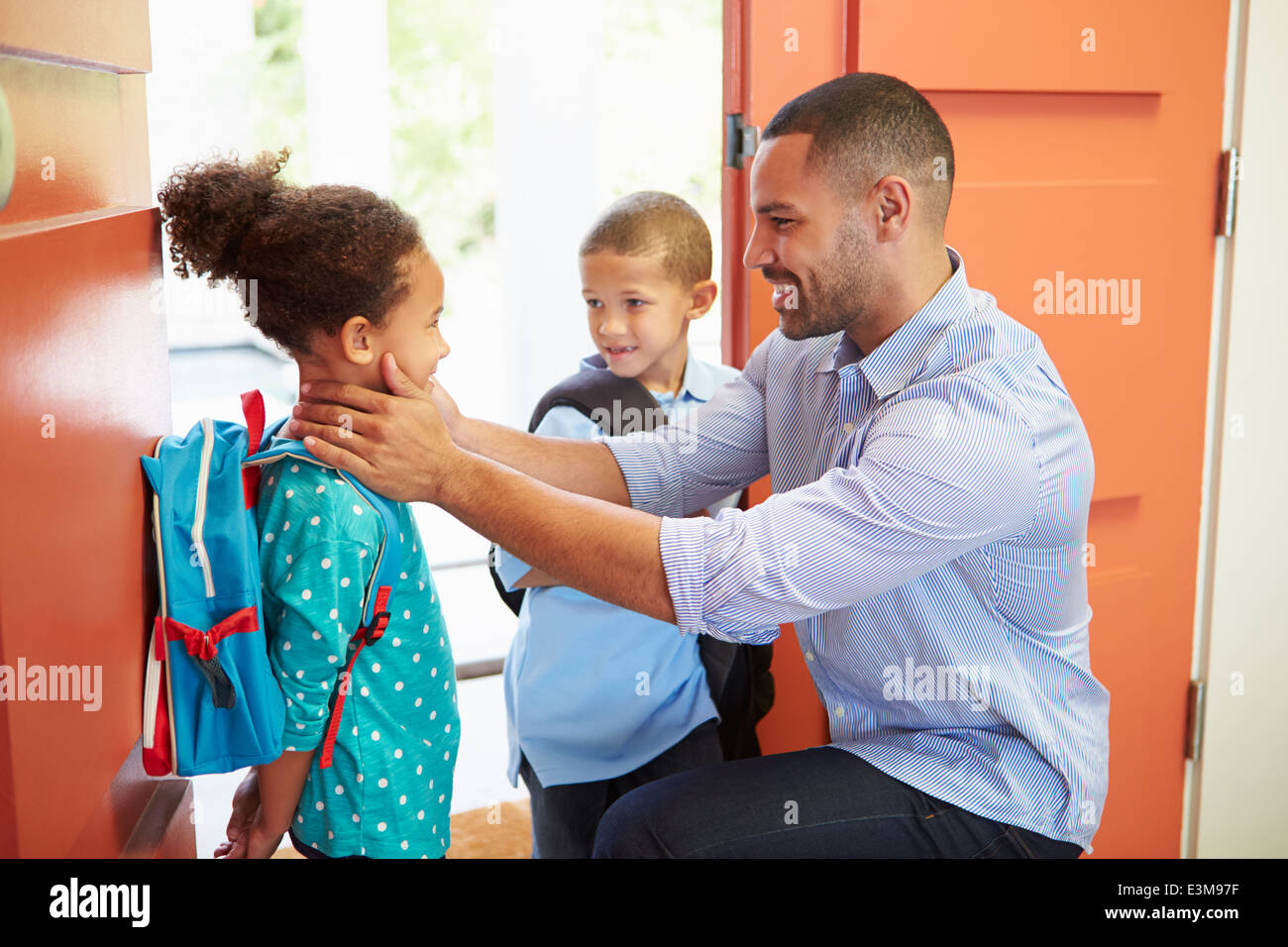 Father Saying Goodbye To Children As They Leave For School Stock Photo