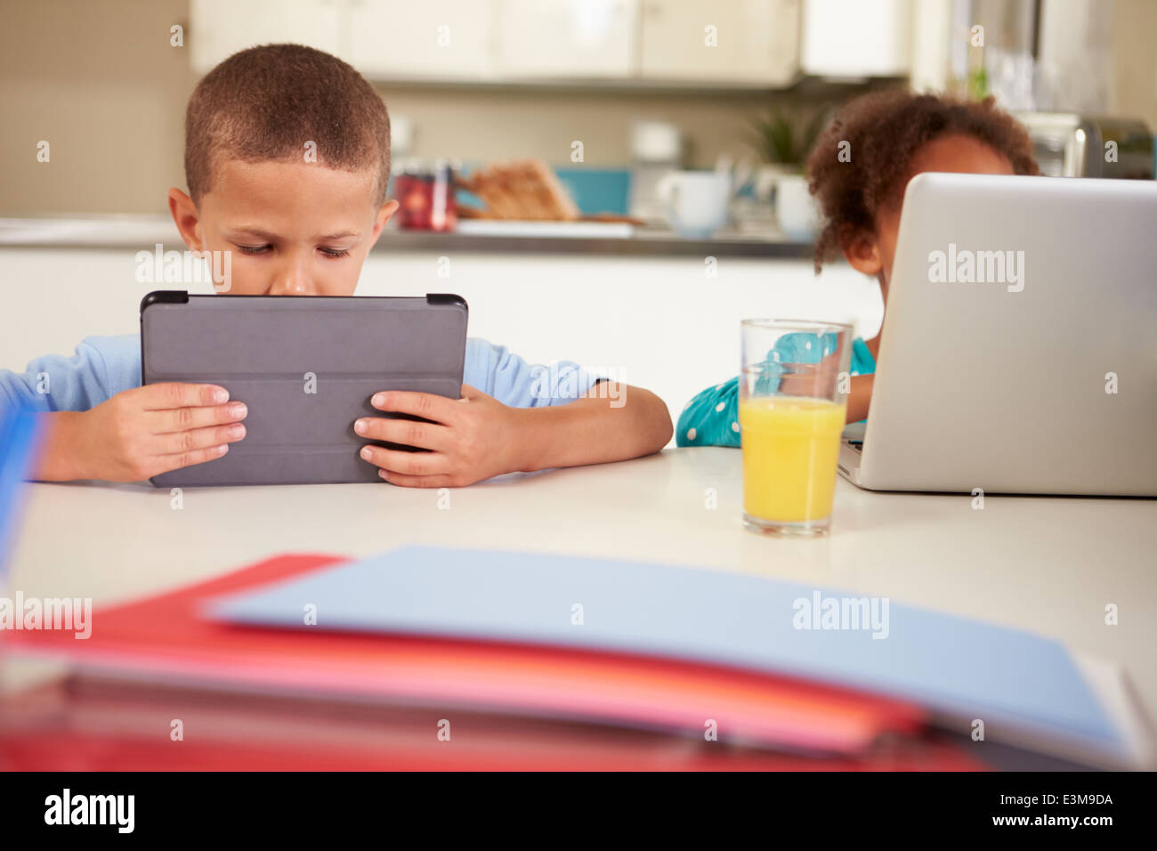 Children Using Laptop And Digital Tablet To Do Homework Stock Photo - Alamy
