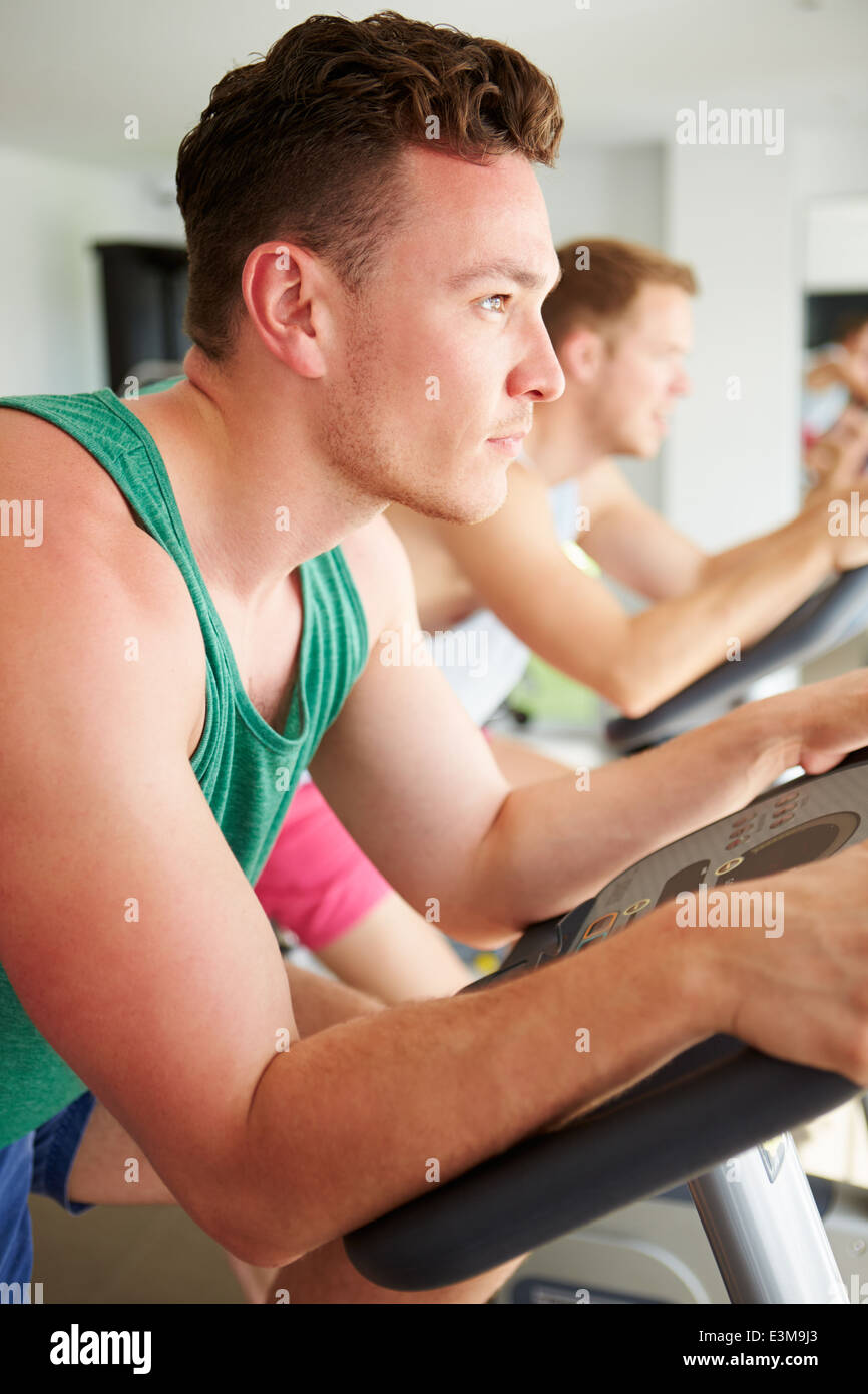 Two Young Men Training In Gym On Cycling Machines Together Stock Photo