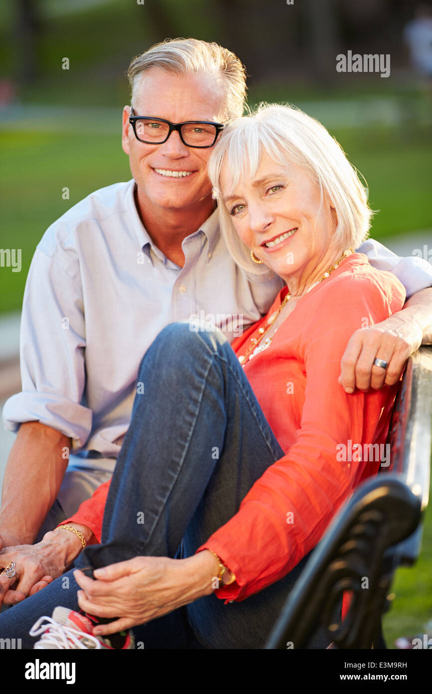 Mature Romantic Couple Sitting On Park Bench Together Stock Photo - Alamy