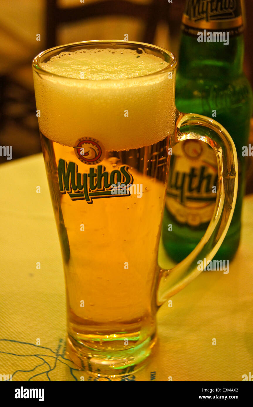 A printed glass of Mythos Greek beer on a bar on Kos, Greece pub table drinks glasses Stock Photo