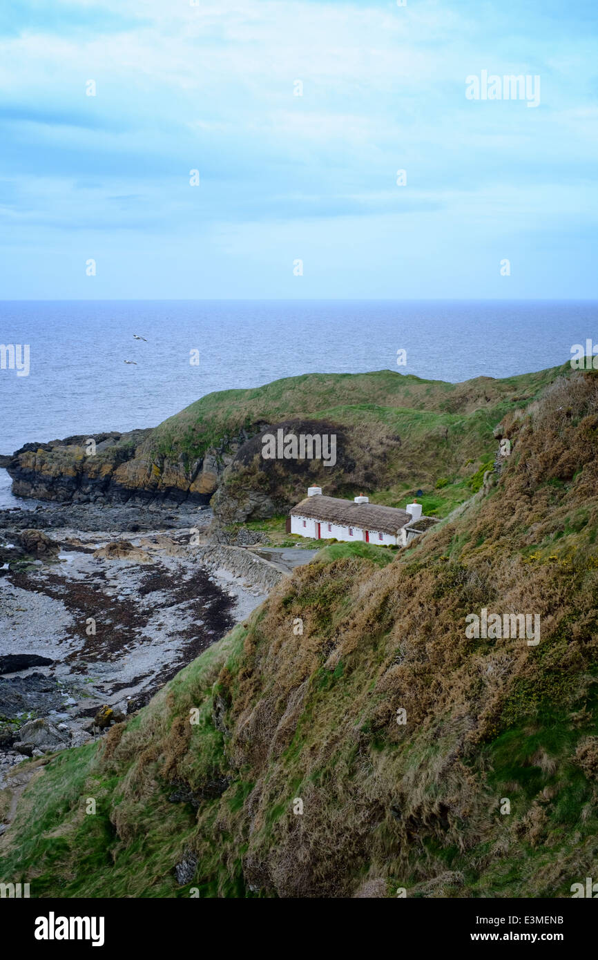 traditional thatched cottages by the sea at Niarbyl on the Isle of Man Stock Photo