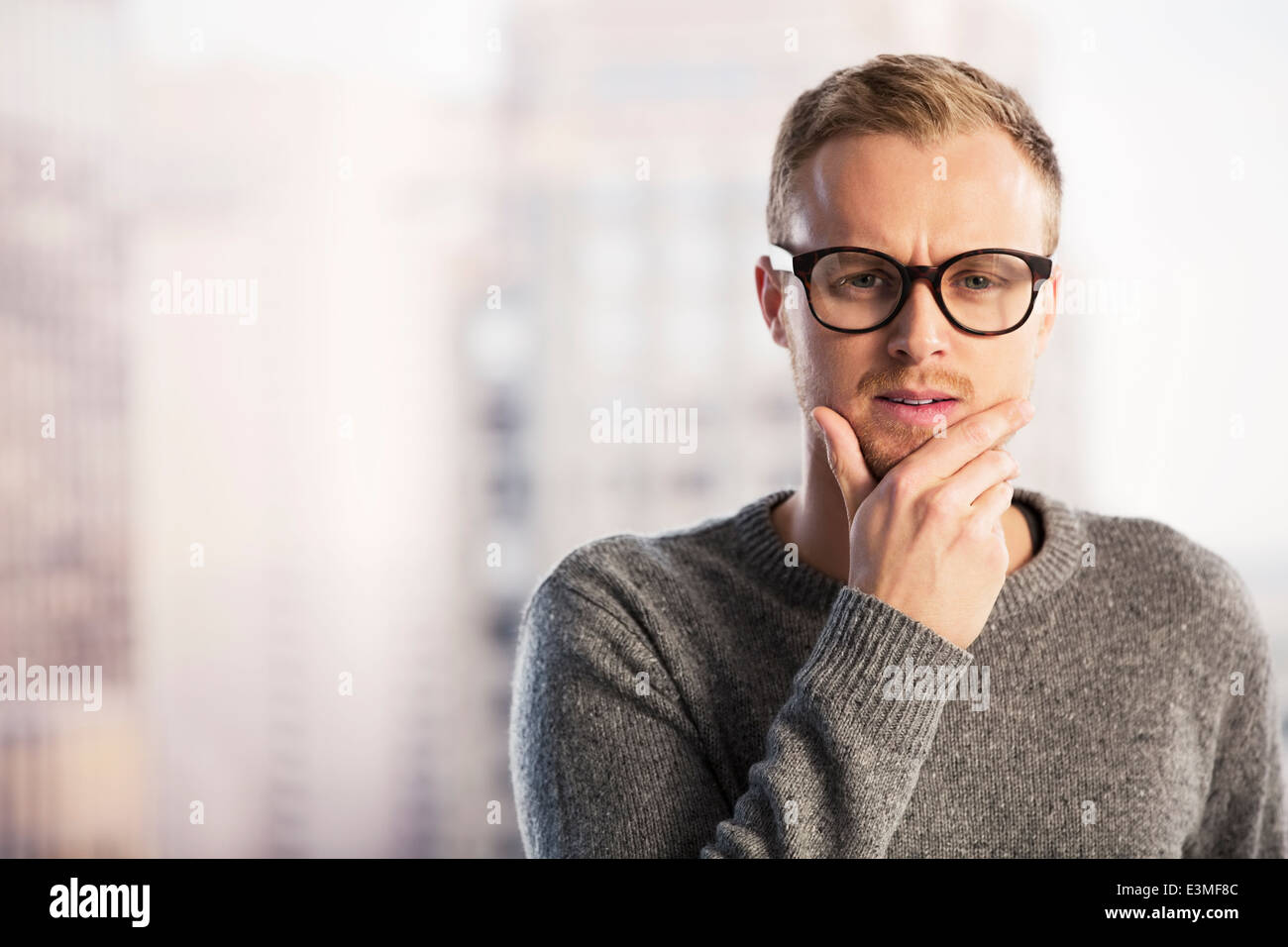 Pensive businessman with hand on chin Stock Photo