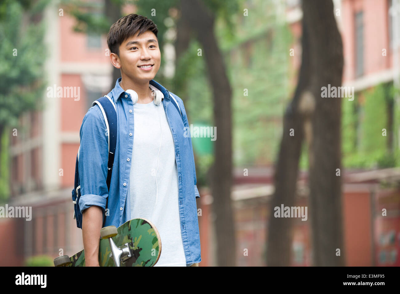 Male college student with skateboard on campus Stock Photo Alamy