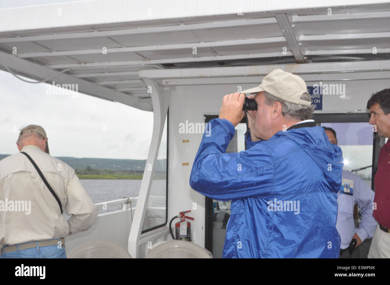 Deputy Regional Director scopes out the island with binoculars. USFWS Photo. Stock Photo