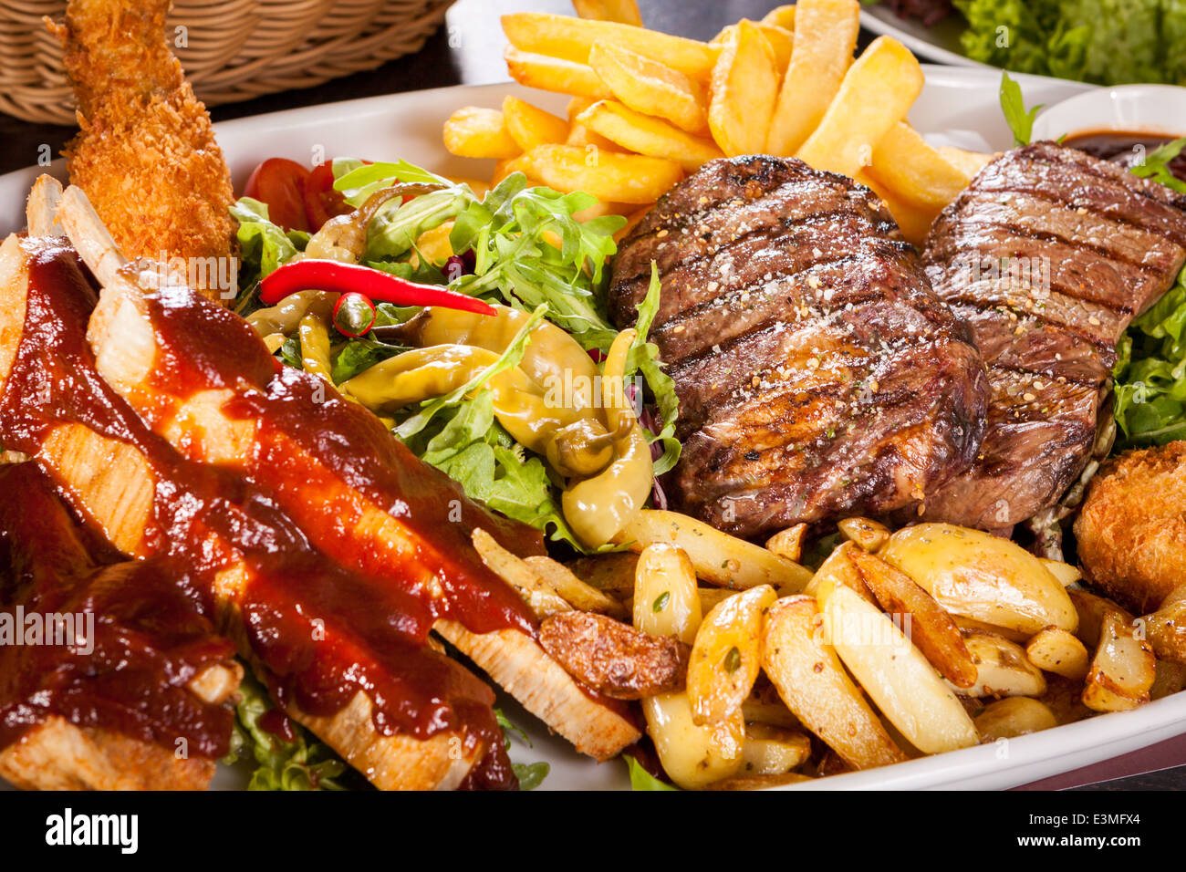 Wholesome platter of mixed meats including grilled steak, crispy crumbed chicken and beef on a