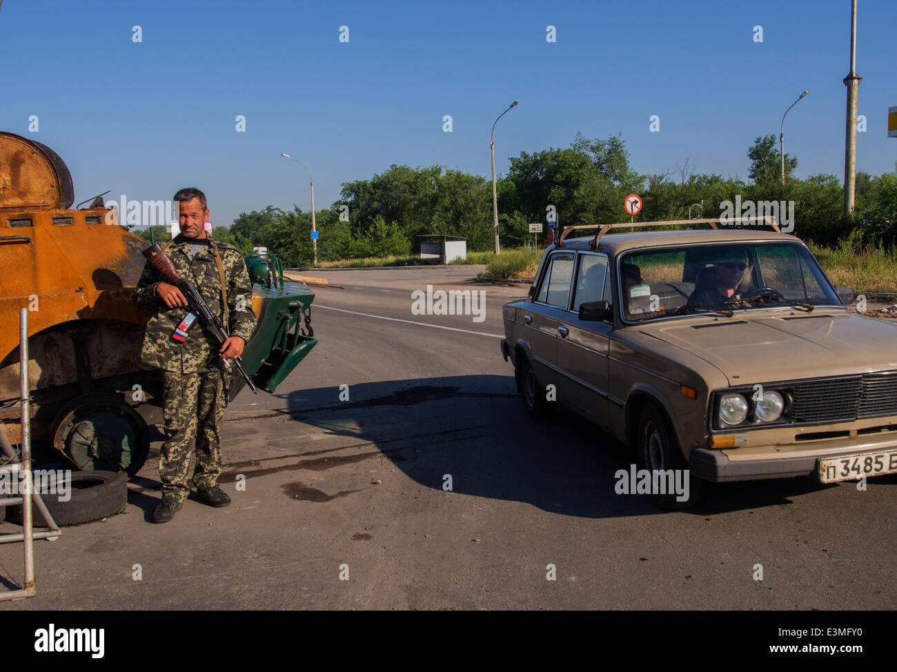 Oleksandrivs'k, Luhans'ka oblast, Ukraine. 24th June, 2014. Armed Pro-Russian rebel posing against the backdrop of the downed armored National Guard of Ukraine on checkpoint in the  Oleksandrivs'k city, Luhans'ka Oblast   --- Due to numerous terrorist attacks on the position of Ukrainian troops June 24, 2014 was hit by Mi-8 helicopter, killing nine Ukrainian military. As a result of this and other terrorist attacks, President of Ukraine Petro Poroshenko does not exclude that a ceasefire may be canceled prematurely. Credit:  Igor Golovnov/Alamy Live News Stock Photo