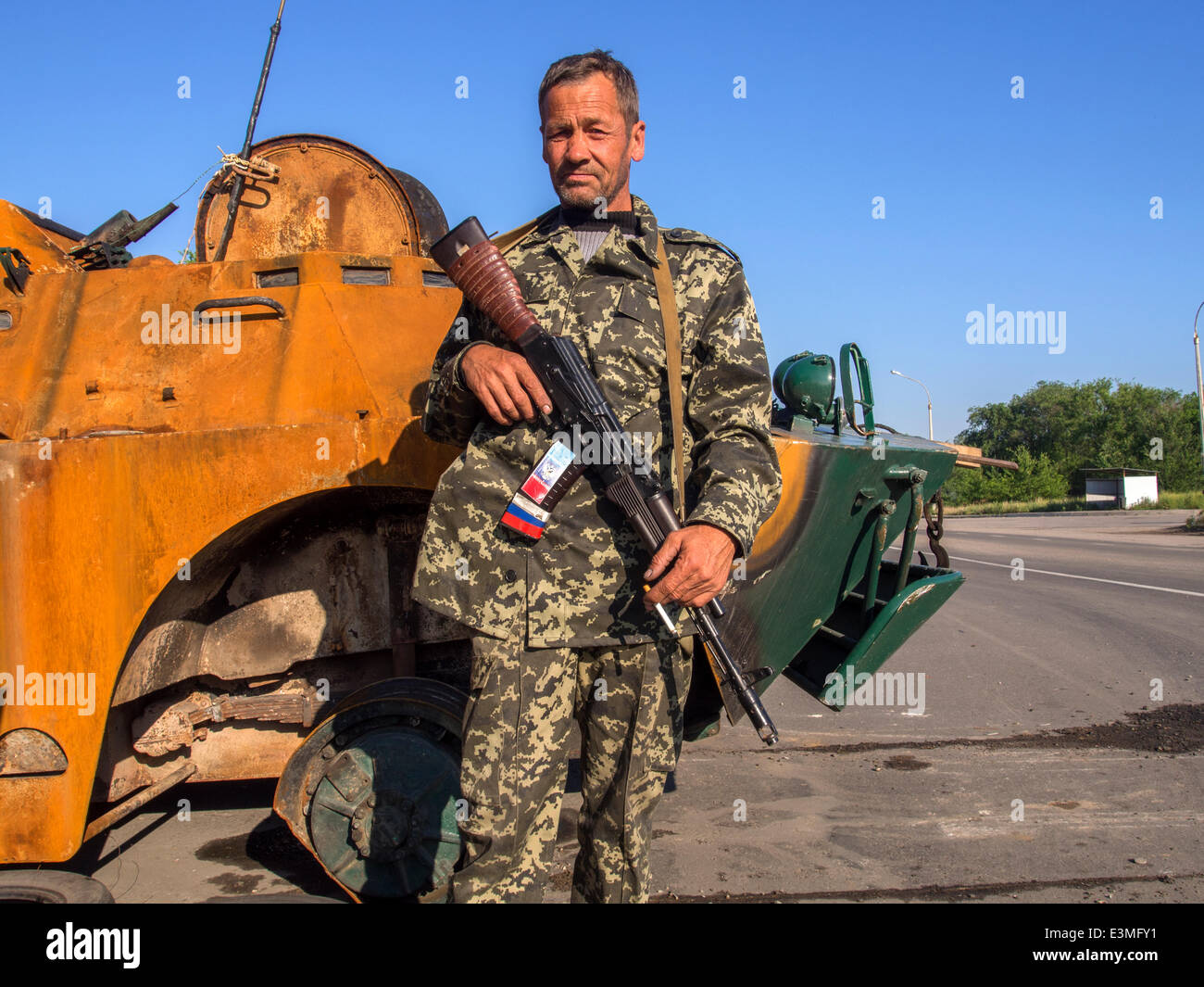 Oleksandrivs'k, Luhans'ka oblast, Ukraine. 24th June, 2014. Armed Pro-Russian rebel posing against the backdrop of the downed armored National Guard of Ukraine on checkpoint in the  Oleksandrivs'k city, Luhans'ka Oblast   --- Due to numerous terrorist attacks on the position of Ukrainian troops June 24, 2014 was hit by Mi-8 helicopter, killing nine Ukrainian military. As a result of this and other terrorist attacks, President of Ukraine Petro Poroshenko does not exclude that a ceasefire may be canceled prematurely. Credit:  Igor Golovnov/Alamy Live News Stock Photo
