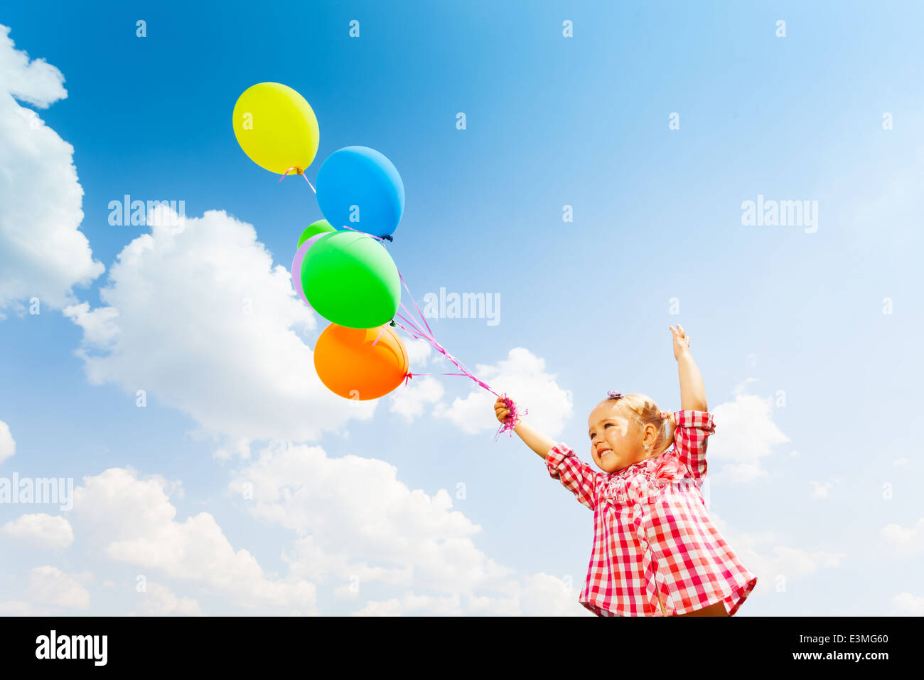 Cute girl with many balloons on sky background Stock Photo - Alamy