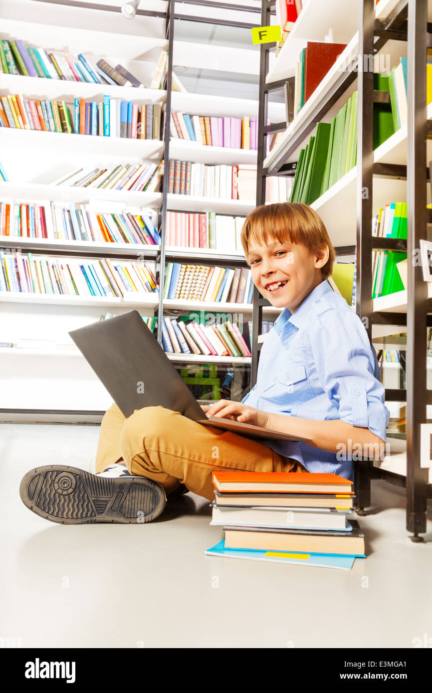 Smiling boy sitting with laptop on the floor Stock Photo - Alamy