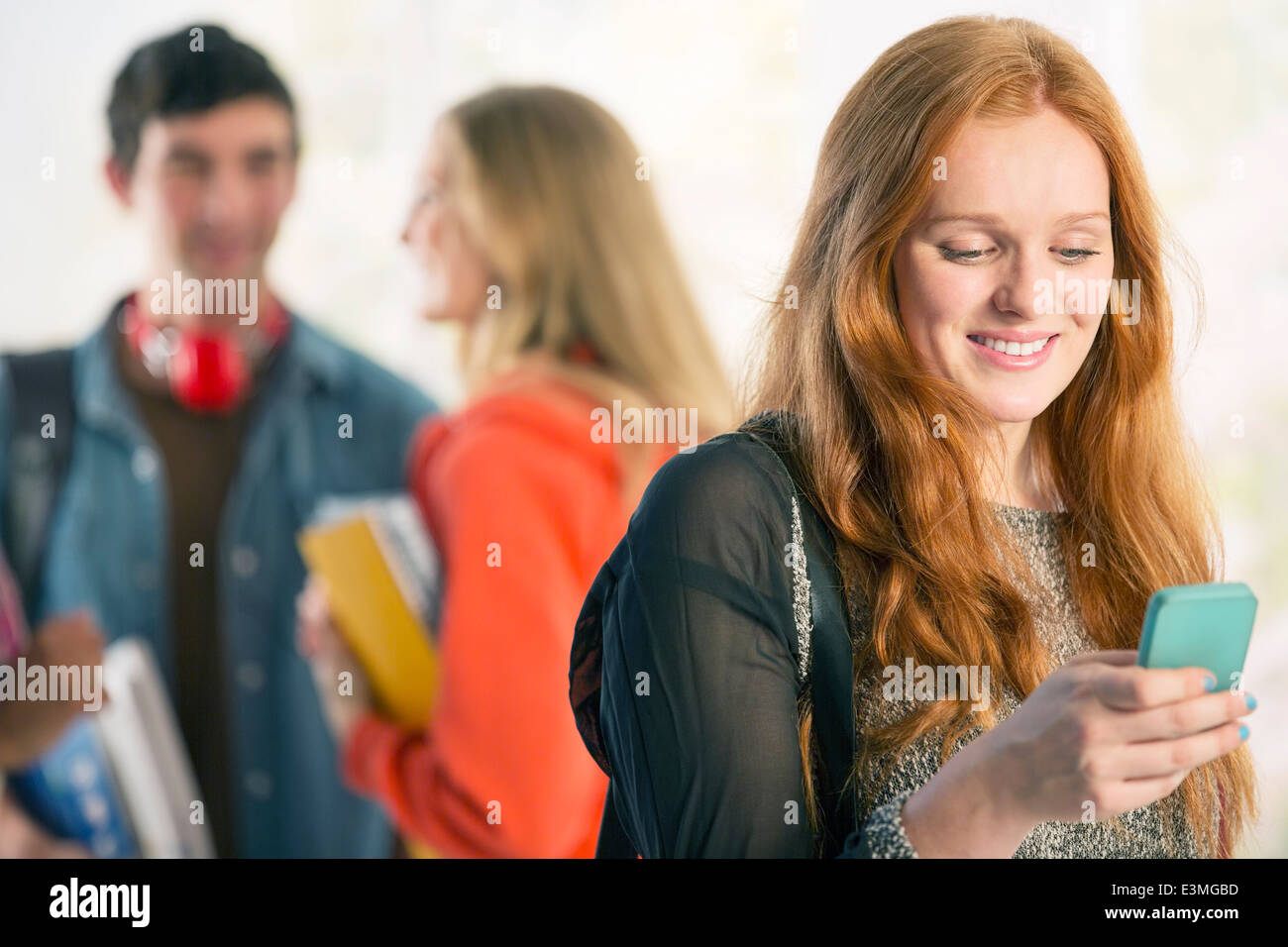 College student text messaging with cell phone Stock Photo