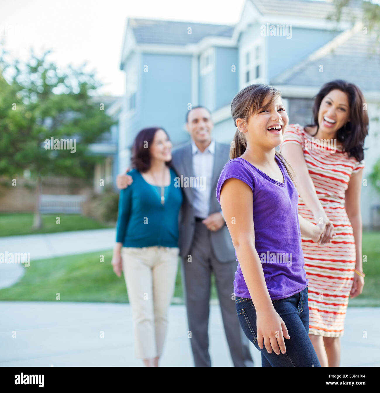 Multi-generation family walking outside house Stock Photo