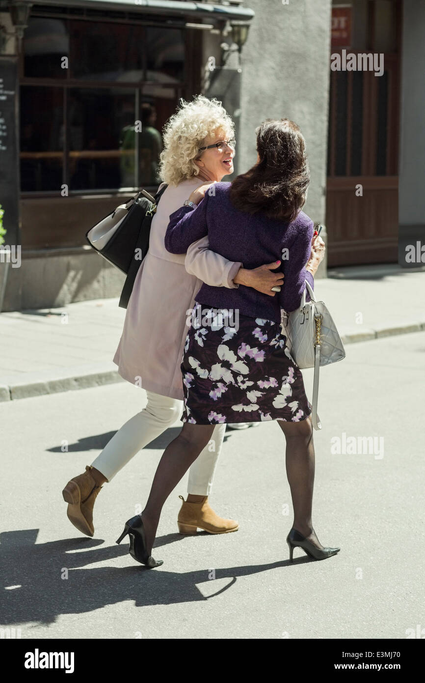 Full length rear view happy senior women walking on street Stock Photo ...