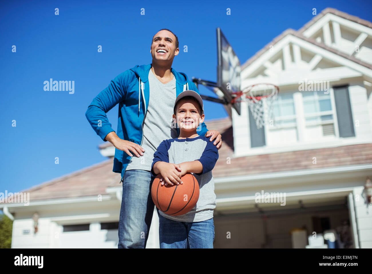 Father and son with basketball in driveway Stock Photo